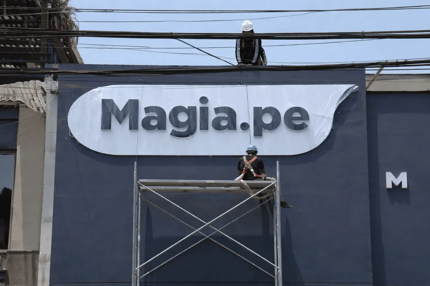 Instalación del letrero corpóreo iluminado de Magia.pe en su fachada, fabricado por Acrílica del Perú